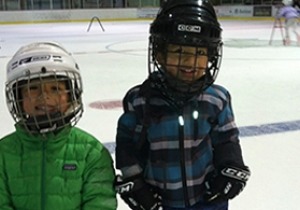 Two children skating at an ice rink