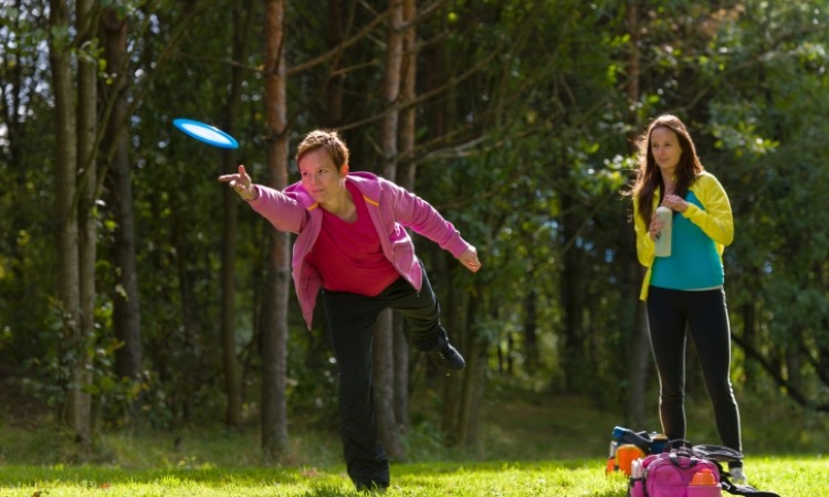Two woman playing disc golf