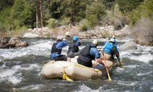 Four people on raft going down a river